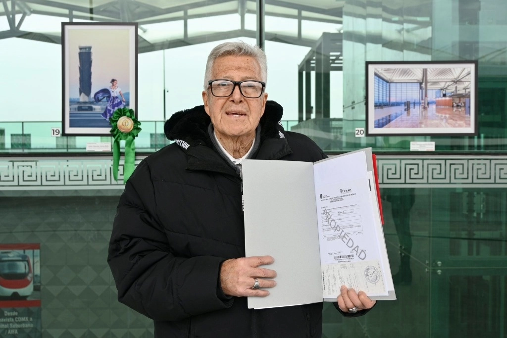Un adulto mayor recibe las escrituras de su vivienda. Foto Infonavit