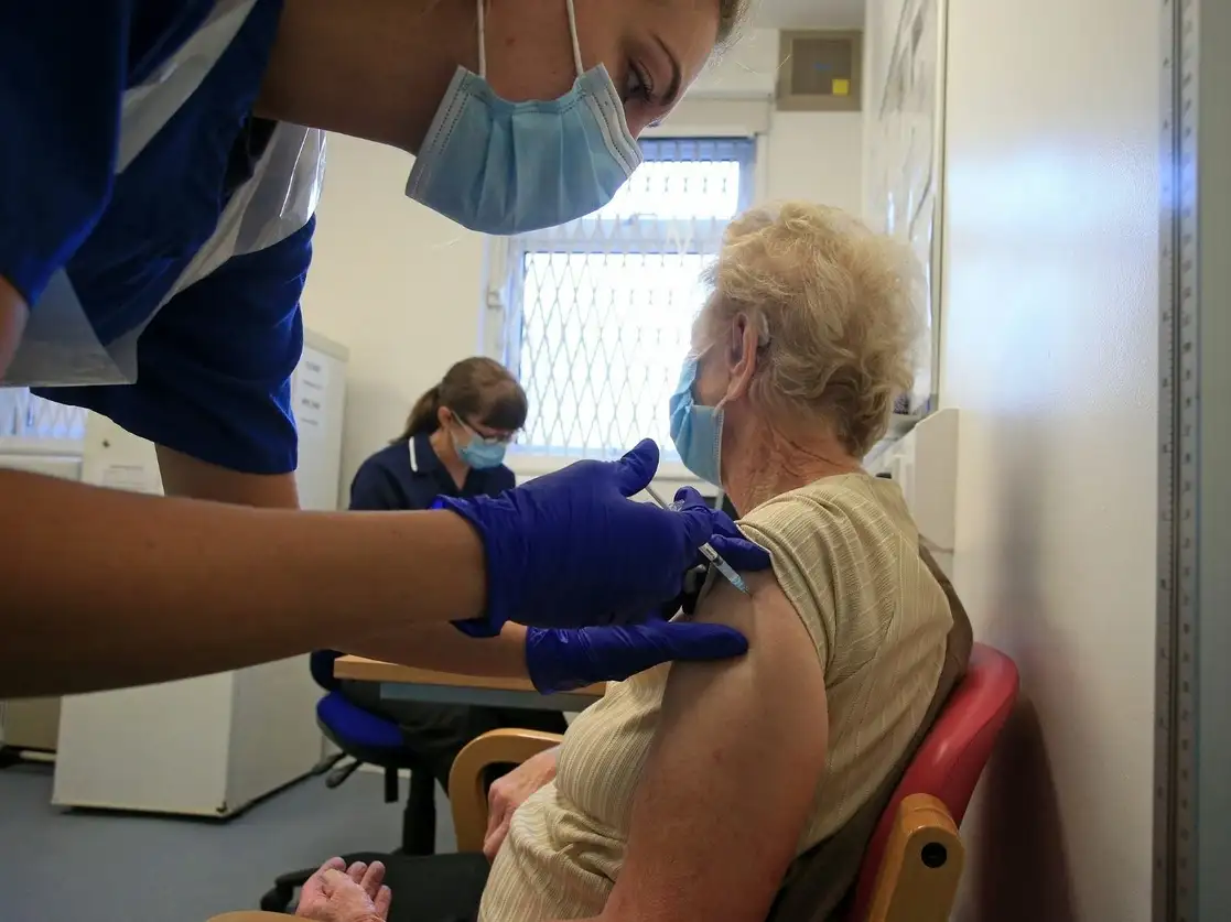 Una enfermera administra la vacuna de Pfizer-BioNTech a una paciente en un hospital de Inglaterra. Foto Afp