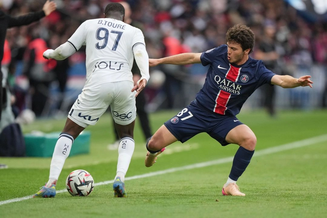 João Neves del PSG (derecha), busca quitarle la posesión del balón a Fode Ballo, del Le Havre, en duelo de la Ligue 1 en el estadio Parque de los Príncipes de París, el 19 de abril de 2025. Foto