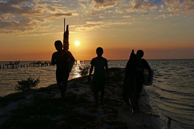 Tres jóvenes se aventuran a la pesca de camarón con redes y equipo improvisado por ellos mismos, en Champotón, Campeche. Foto Cuartoscuro / archivo 