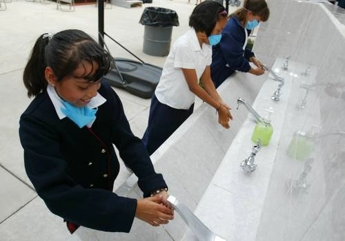 Un grupo de niñas se lava las manos para prevenir contagios. Foto Roberto García Ortiz / Archivo 