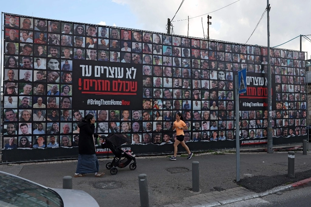 Cartel con retratos de rehenes israelíes, retenidos en la Franja de Gaza por militantes de Hamas, el 17 de febrero de 2025. Foto Afp