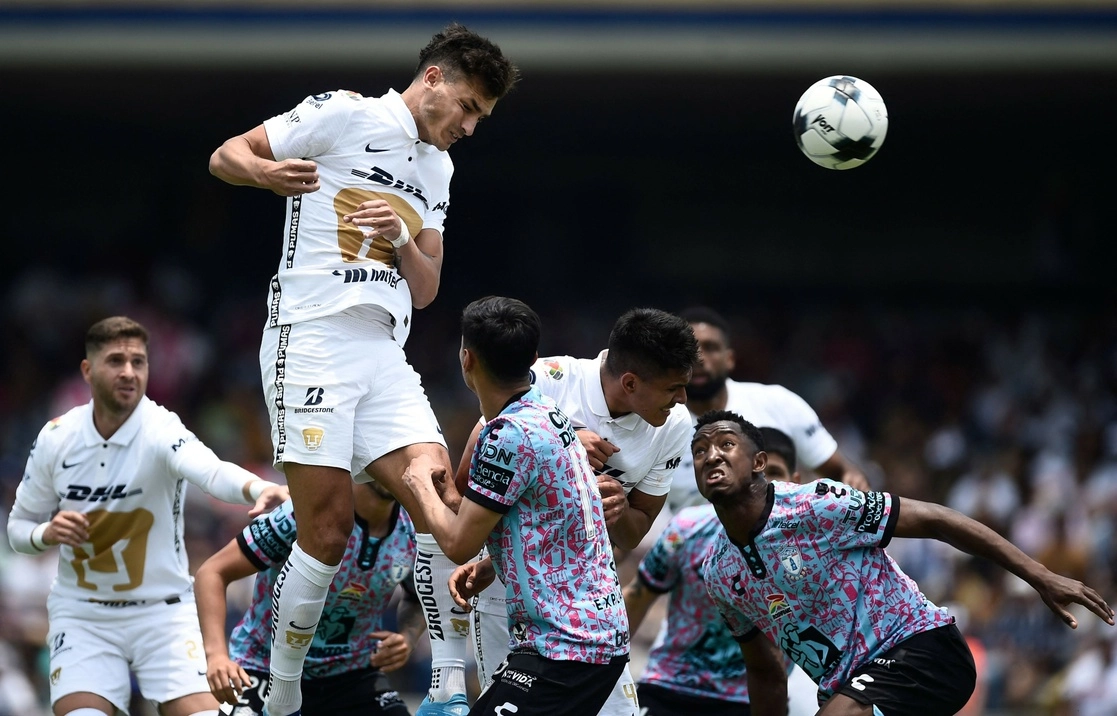 Juan Dinenno de cabecea el balón para anotar durante el encuentro contra los Tuzos en el estadio Olímpico Universitario. Foto Afp