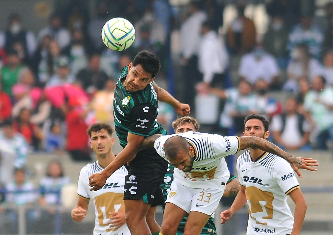 Dani Alves (der.), de Pumas, pelea por el valón con Eduardo Aguirre, de Santos, durante el parido del torneo de Apertura de futbol en el Estadio Olímpico de la Ciudad de México, el 21 de agosto de 2022. Foto Afp 