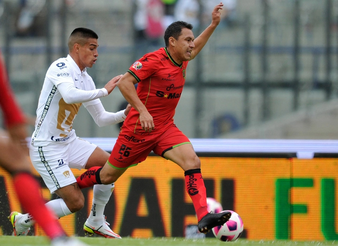 Alberto Costa de Bravos de Juárez y Flavio Álvarez de Pumas compiten por la posesión del balón en el duelo de la fecha 13 del A2021. Foto Afp