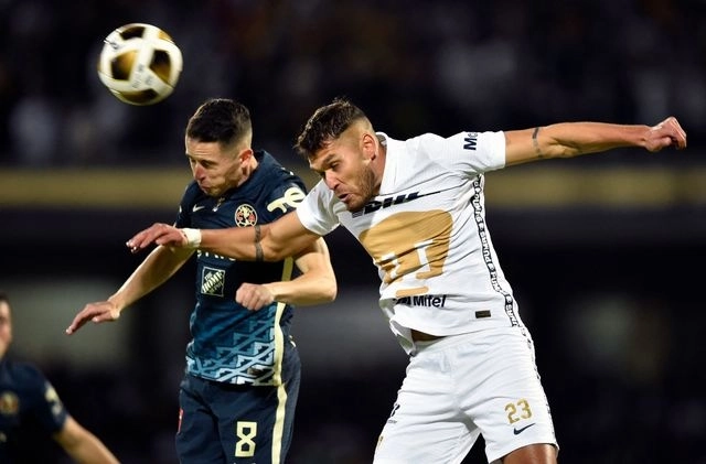 El defensor de Pumas, Nicolás Freire (der) disputa la esférica con el delantero americanista, Álvaro Fidalgo (izq). Foto Afp