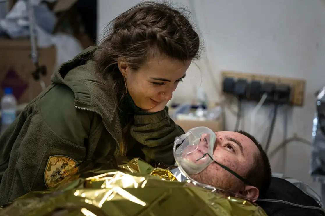 Una médica militar ucrania habla con su compañero herido en el hospital de campaña cerca de Bakhmut, el 26 de febrero de 2023. Foto Ap 