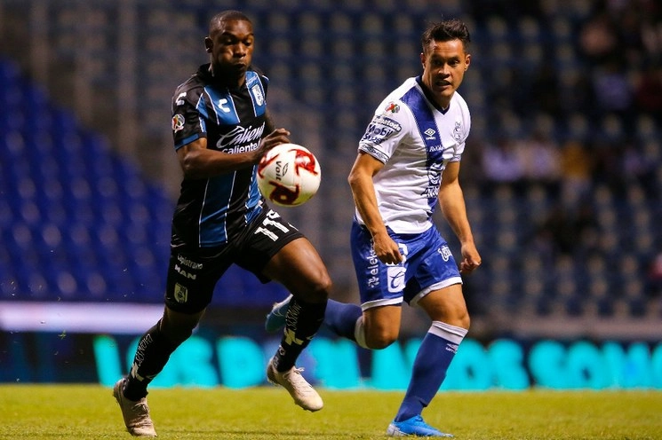 Fabian Castillo (izquierda) del Querétaro y Alan Acosta (derecha) del Puebla disputan el balón. Foto Jam Media