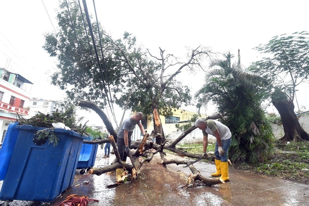 Imagen del 7 de noviembre de 2024 de personas trabajando en la limpieza de árboles caídos tras el paso del huracán Rafael, en La Habana, capital de Cuba. Foto Xinhua