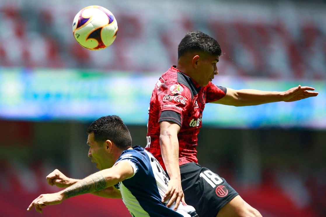 Kevin Castañeda de Toluca y Celso Ortiz del Monterrey disputan un balón aéreo en la cancha del estadio Nemesio Diez, el 11 de abril de 2021. Foto Afp