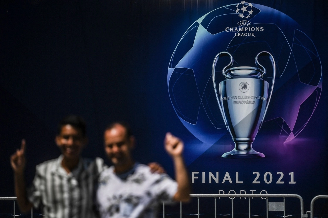 Aficionados se toman fotos frente a un cartel publicitario sobre la ‘Champions’, en Oporto, Portugal, el 28 de mayo de 2021. Foto Afp