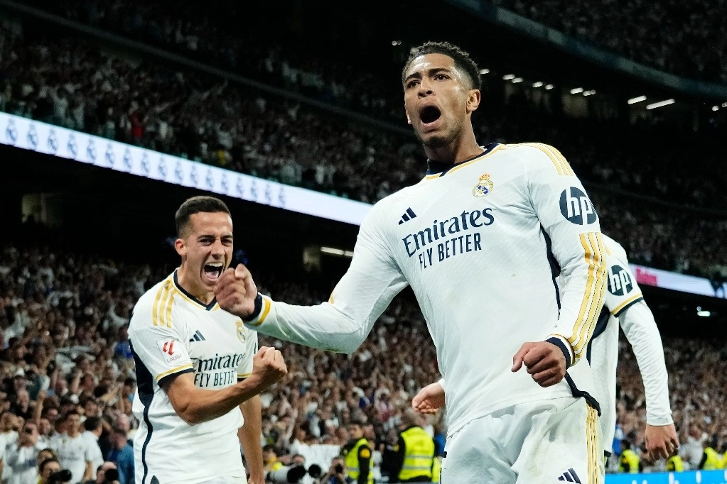 Jude Bellingham, centro, del Real Madrid, celebra con sus compañeros tras anotar el tercer gol de su equipo durante el partido de fútbol de la Liga española entre Real Madrid y Barcelona en el estadio Santiago Bernabeu de Madrid, España, el domingo 21 de abril de 2024. Foto Ap