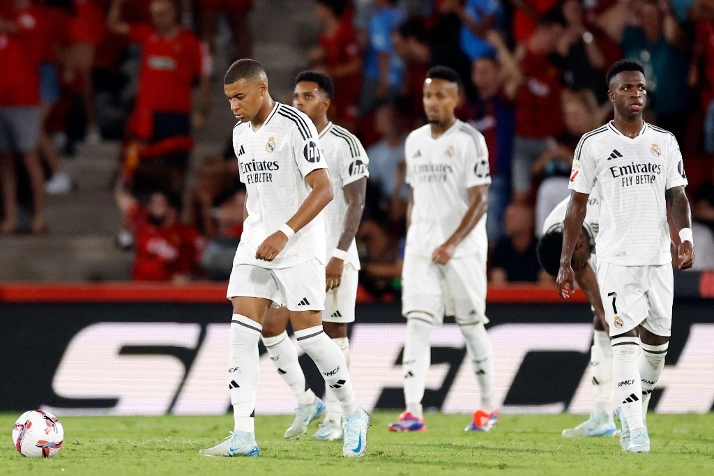 El delantero francés #09 del Real Madrid, Kylian Mbappé (izq.), y sus compañeros de equipo reaccionan durante el partido de futbol de la liga española entre el RCD Mallorca y el Real Madrid CF en el estadio Mallorca Son Moix en Palma de Mallorca el 18 de agosto de 2024. Foto Afp