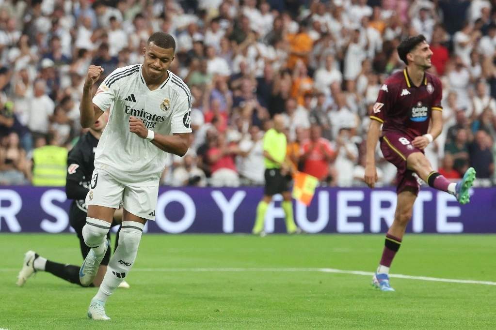 El delantero francés del Real Madrid #09 Kylian Mbappé celebra el gol inaugural, anotado por el centrocampista uruguayo del Real Madrid #08 Federico Valverde, durante el partido de fútbol de la liga española entre el Real Madrid CF y el Real Valladolid FC en el estadio Santiago Bernabéu en Madrid el 25 de agosto de 2024. Foto Afp