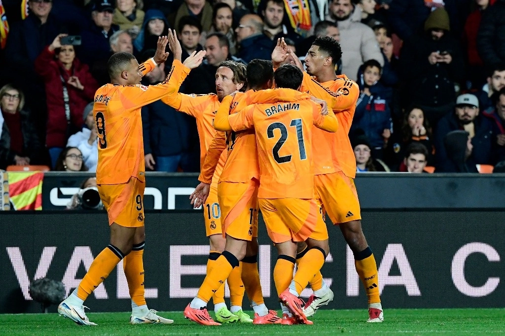 El centrocampista inglés #05 del Real Madrid Jude Bellingham (R) celebra con sus compañeros de equipo después de anotar el segundo gol de su equipo durante el partido de fútbol de la liga española entre Valencia CF y Real Madrid CF en el estadio de Mestalla en Valencia el 3 de enero de 2025. Foto Afp