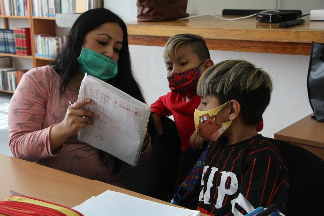 Maestra asesora a dos niños en el Club de Tareas de la alcaldía Magdalena Contreras. Foto Cuartoscuro / Archivo