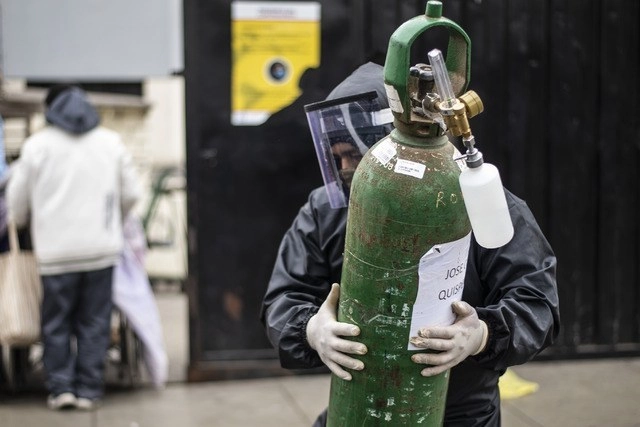 Un hombre carga un tanque de oxígeno vacío para llenarlo para un familiar enfermo con coronavirus, en el Hospital 2 de Mayo de Lima, Perú. Foto Afp