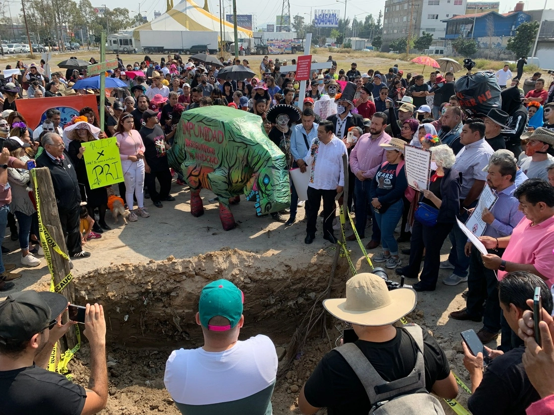 La figura de dinosaurio fue enterrada en un socavón abierto sobre el camellón central del Bordo de Xochiaca, el 1 de noviembre de 2022. Foto René Ramón