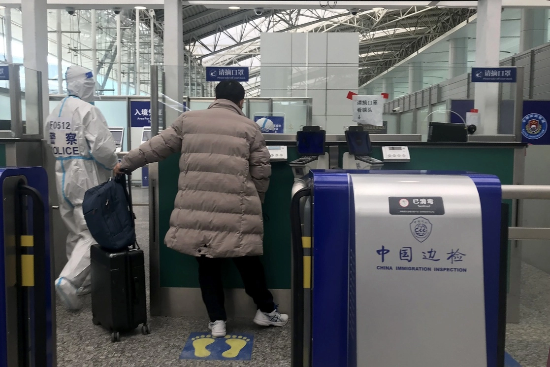 Un viajero se prepara para cruzar inmigración en el aeropuerto de Guangzhou Baiyun, en la provincia china de Guangdong, el 25 de diciembre de 2022. Foto Ap 
