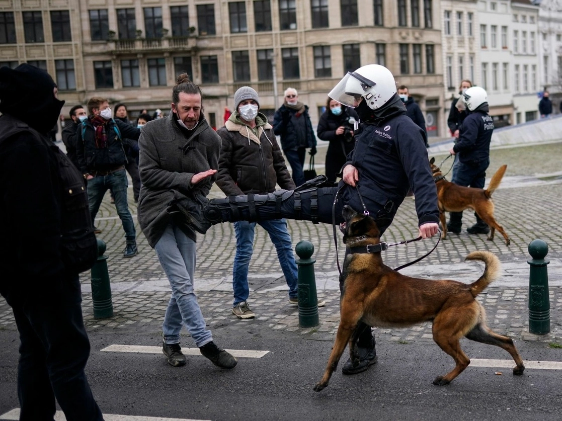 Un policía patea a un manifestante durante una protesta realizada contra las medidas restrictivas aplicadas en Bruselas por la epidemia de Covid-19. Según medios de comunicación belgas, alrededor de 200 personas han sido arrestadas por el rechazo a acciones como el toque de queda o el cierre de bares y restaurantes, el 31 de enero de 2021. Foto Ap