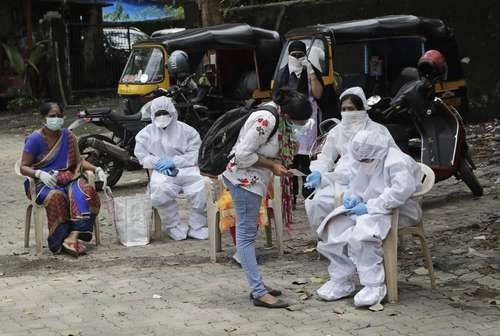 Trabajadores de la salud esperan para tomar pruebas de Covid en un campamento en Mumbai, India. El país llegó a 2 millones 27 mil 74 casos, 62 mil 538 más en un día, y a 41 mil 585 decesos.Foto Ap