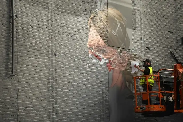 Un artista trabaja en un mural sobre el coronavirus al norte de Manchester, Inglaterra. Foto Afp 