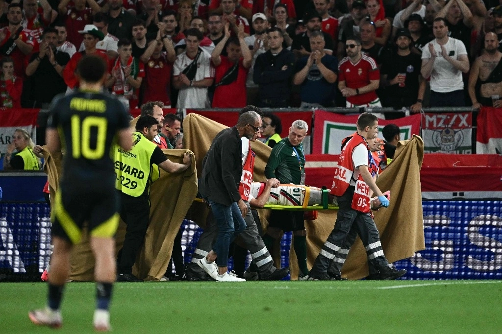 Los paramédicos sostienen un paño alrededor del delantero húngaro #19 Barnabas Varga, quien es evacuado en camilla durante el partido de futbol del Grupo A de la UEFA Euro 2024 entre Escocia y Hungría en el Stuttgart Arena, Alemania, el 23 de junio de 2024. Foto Afp