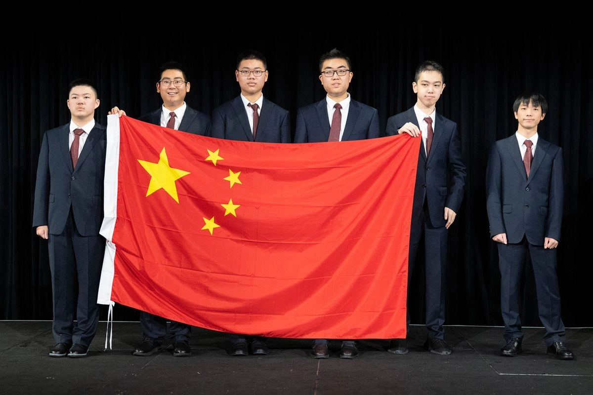 El competidor chino Xu Qiming, quien ayudó a portar su bandera nacional mientras con dificultad caminaba junto a sus compañeros, intentando controlar sus expresiones faciales involuntarias. Foto