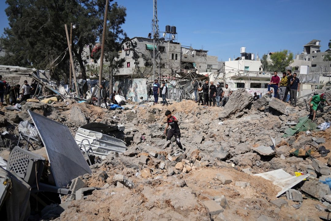 Un niño camina sobre los escombros de una escuela utilizada como refugio para residentes desplazados que fue atacada dos veces por el ejército israelí, matando a más de 25 personas, en Bureij, en el centro de la franja de Gaza, el 7 de mayo de 2025. Foto
