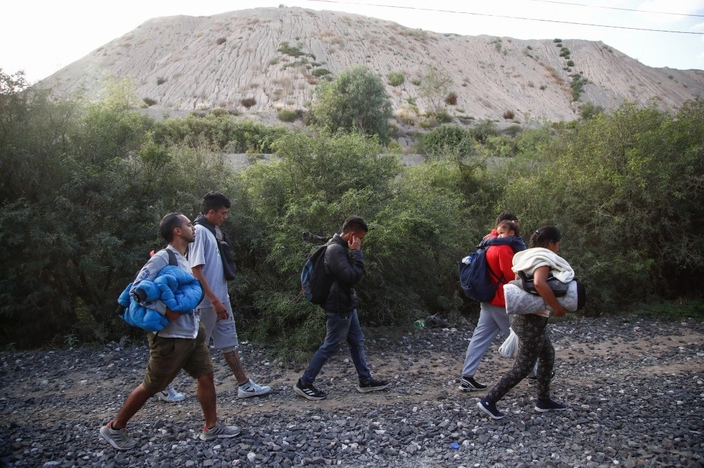 Migrantes caminan sobre las vías del tren en el tramo que va de Huehuetoca a Apaxco, en el estado de México, el 12 de octubre de 2023. Foto Víctor Camacho