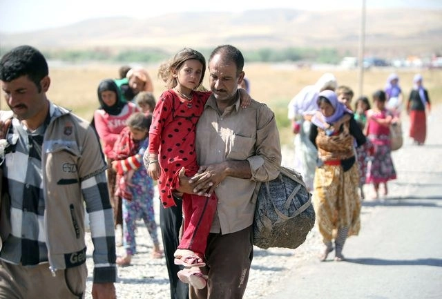 Desplazados iraquíes de la comunidad yazidíes cruzan la frontera siria-iraquí. Foto Afp 
