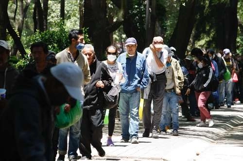 Cientos de personas hacen fila para acceder a una de las 260 raciones que se entregan en el Comedor Móvil, instalado en el Jardín Ramón López Velarde, en la Ciudad de México. Foto Roberto García Ortiz
