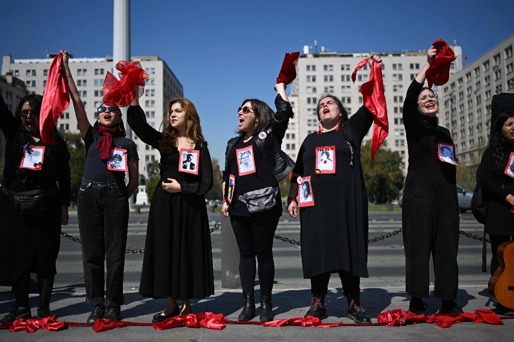 Manifestantes recordaron ayer a víctimas de la dictadura militar, afuera del palacio de La Moneda, en Santiago. Foto Afp 