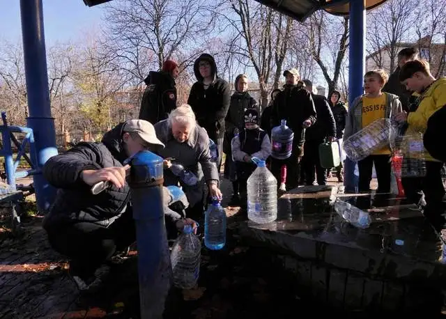 Residentes de Kiev acudieron ayer a llenar contenedores de agua, en un parque de Kiev, tras los bombardeos rusos. Foto Afp 