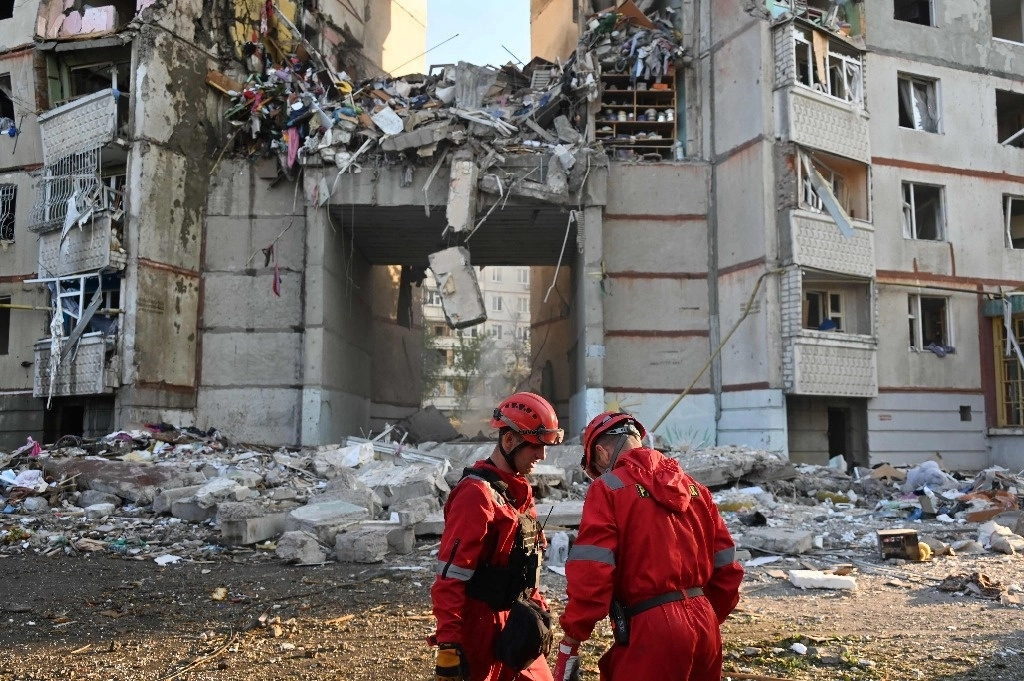 Los rescatistas del Servicio Estatal de Emergencia de Ucrania se encuentran junto a un edificio de apartamentos destruido durante un ataque aéreo en Kharkiv, el 24 de septiembre de 2024, en medio de la invasión rusa de Ucrania. Foto Afp