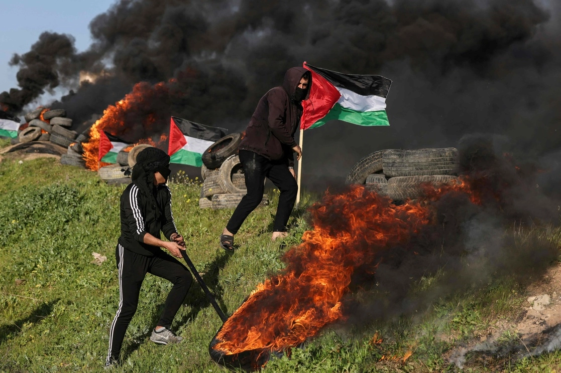 Jóvenes palestinos queman llantas durante una protesta cerca de la frontera entre Israel y Gaza, el 22 de febrero de 2023. Foto Afp 