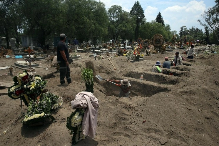 Trabajadores cavan tumbas para inhumar a personas fallecidas por Covid-19 en panteones de la CDMX. Foto Jesús Villaseca/Archivo