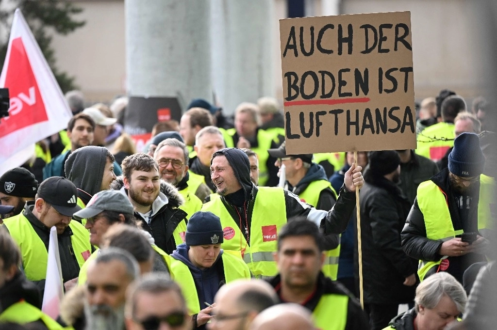 Empleados de la aerolínea alemana Lufthansa y miembros del sindicato alemán Verdi protestan con un cartel que dice "También el suelo es Lufthansa" en las afueras del aeropuerto de Frankfurt, Alemania occidental, el 20 de febrero de 2024, durante una huelga del personal de tierra. Foto Afp