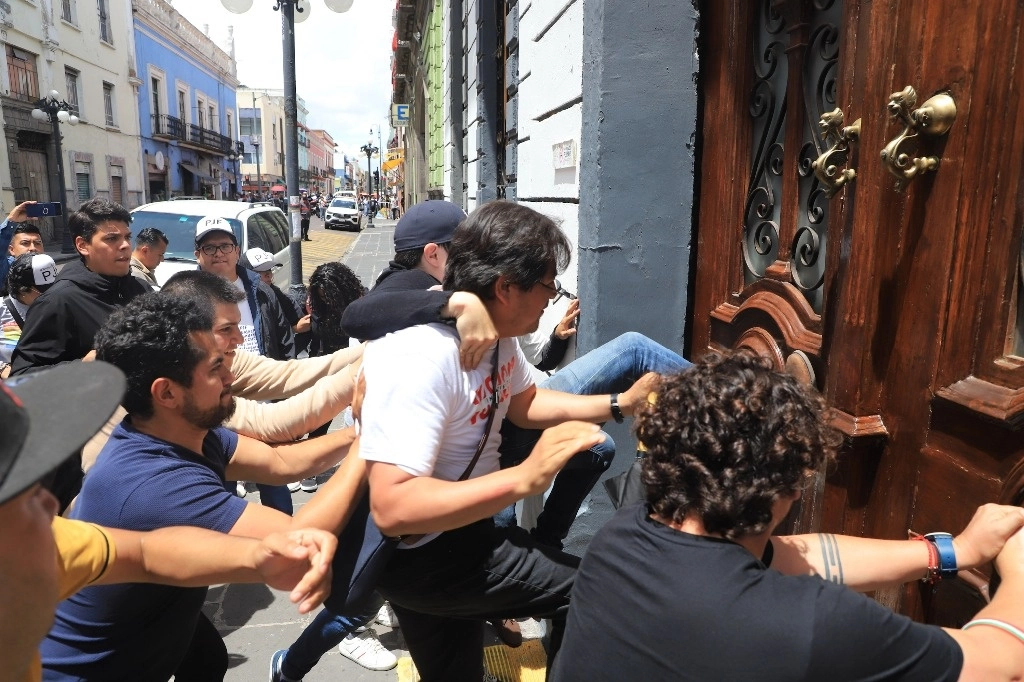 En un último intento de frenar por la fuerza la reforma al Poder Judicial, personas que se identificaron como trabajadores del sector generaron disturbios en las sedes legislativas estatales, como en Baja California y Colima, con saldo de al menos dos heridos y dos detenidos. En Yucatán, los manifestantes irrumpieron en el recinto e incluso bajaron hasta las curules de los diputados, mientras en Puebla (en la imagen) patearon las puertas y las golpearon con palos, pero no lograron ingresar al lugar de la sesión. Foto Es Imagen 
