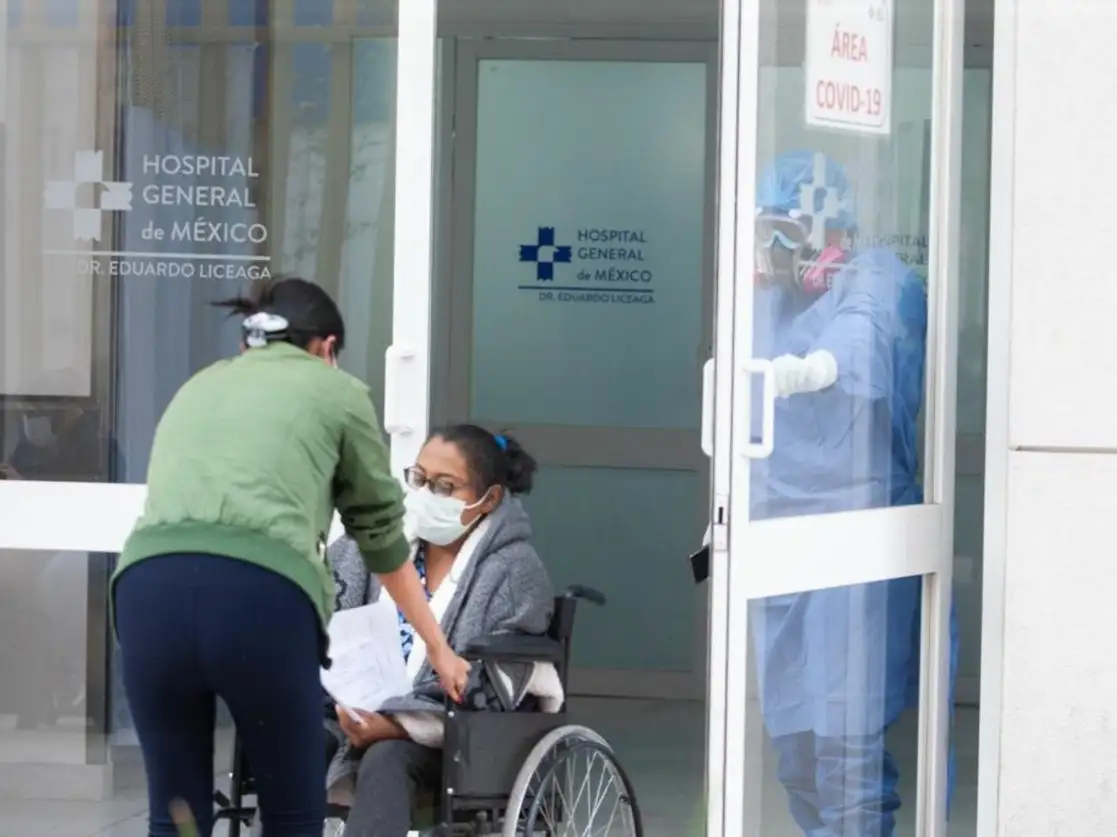 Una paciente es ayudada por una familiar para ingresar al área Covid-19 del Hospital General de México para ser evualuada, el 15 de enero de 2021. Foto Pablo Ramos