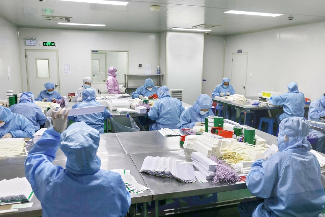 Trabajadores producen kits de prueba de antígenos para el covid-19 en una fábrica en Nantong, en la provincia oriental china de Jiangsu, el 19 de diciembre de 2022. Foto Afp