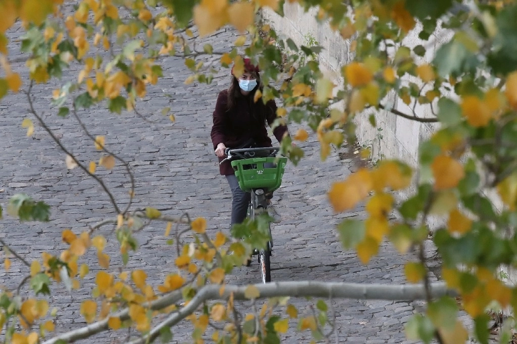 Una joven anda en bicicleta por las calles de París. Foto Afp