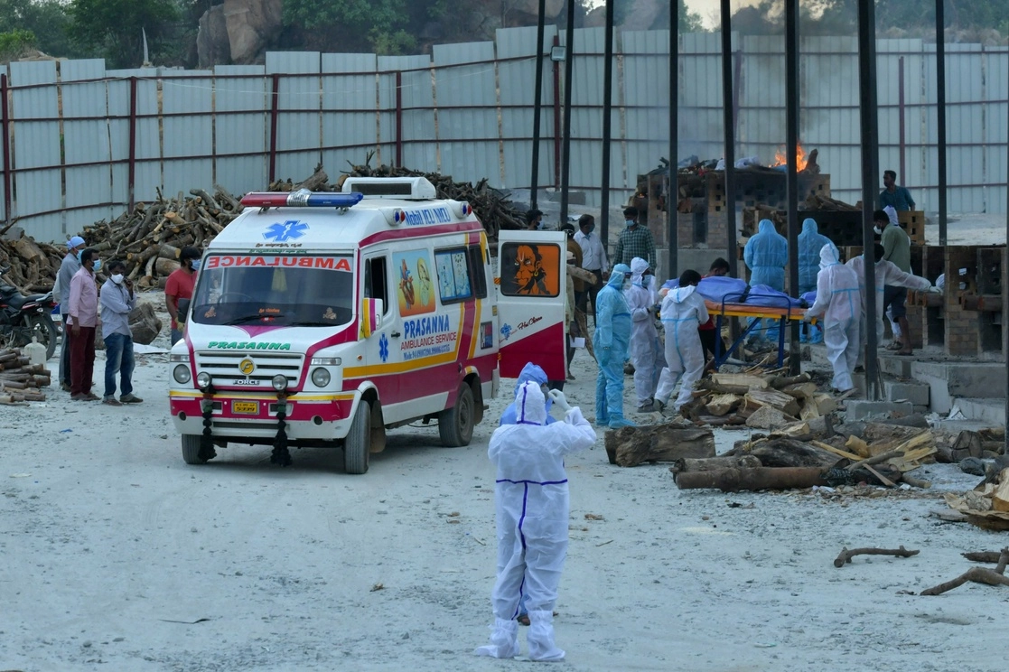 A las afueras de Bangalore, India, familiares y funerarias llevan a una de las víctimas que murieron por el nuevo coronavirus a un crematorio improvisado en una cantera de granito agotada. Foto Afp