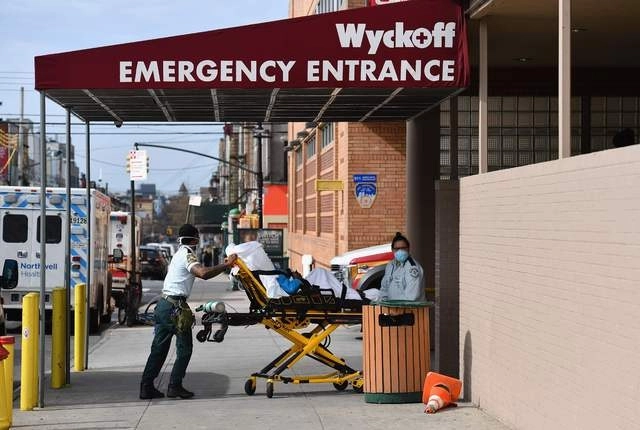Trabajadores médicos ingresas a un paciente con coronavirus por la sala de emergencias de un hospital en Brooklyn, Nueva York. Foto Afp 