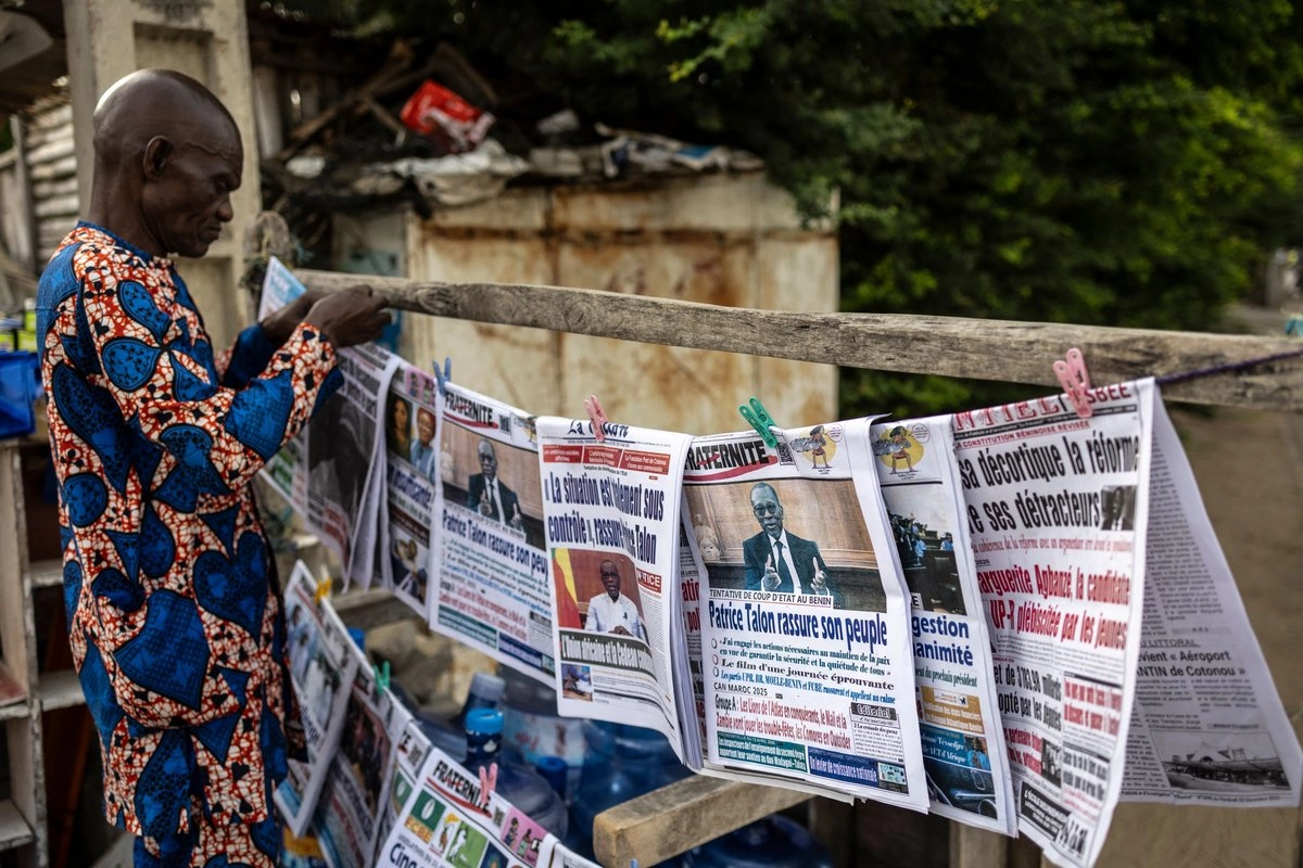 Un vendedor coloca periódicos en un puesto en Cotonú, ciudad de Benín en África, el 8 de diciembre de 2025. 