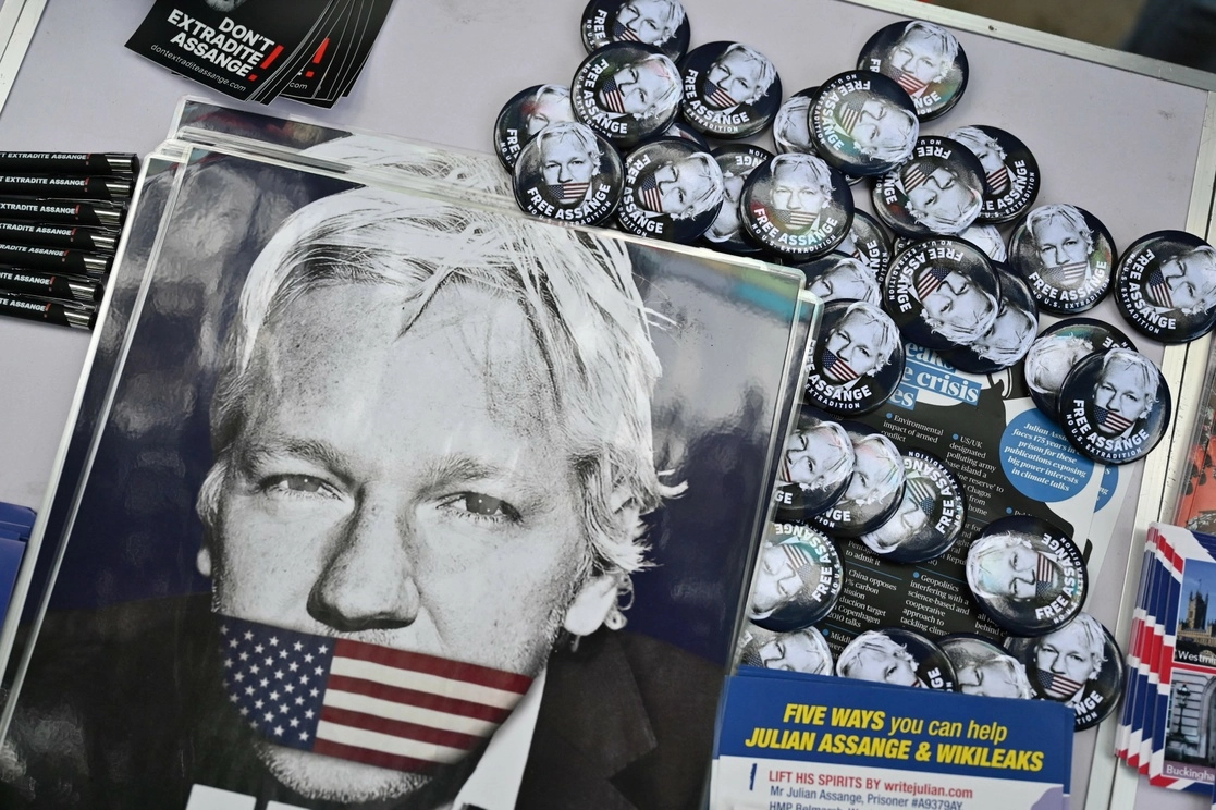 Carteles y emblemas alusivos al fundador de Wikileaks, Julian Assange, tendidos en una mesa frente al edificio del Ministerio del Interior del Reino Unido, en Londres, el 17 de mayo de 2022, durante una manifestación en contra de la extradición del activista. Foto Afp
