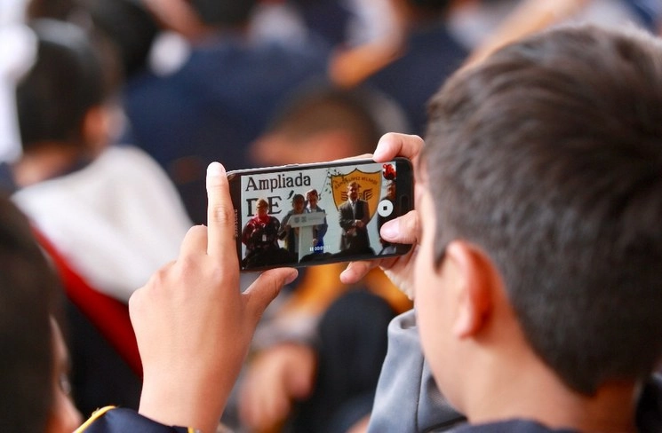 Un menor toma video de la jefa de Gobierno, Claudia Sheinbaun durante una visita a una escuela de la CDMX en imagen de archivo. Foto Luis Castillo