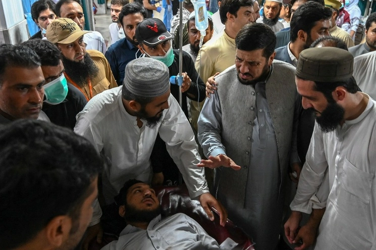 El gobernador de la provincia de KP, Haji Ghulam Ali (segundo a la derecha), saluda a un hombre herido en un hospital de Peshawar, un día después de que al menos 44 personas murieran y decenas más resultaran heridas por un atentado suicida en una reunión política de un principal partido islámico en el noroeste de Pakistán, el 30 de julio de 2023. Foto Afp