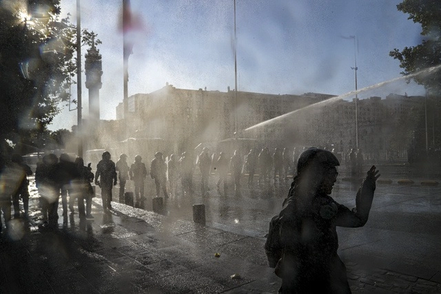 La policía replegó a los manifestantes ayer frente al Palacio presidencial de La Moneda, cuando exigían la renuncia del presidente Sebastián Piñera, en Santiago de Chile. Foto Ap