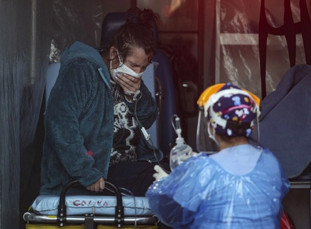Un paciente con coronavirus es atendido por un médico en el hospital de San José de Santiago. Foto Ap